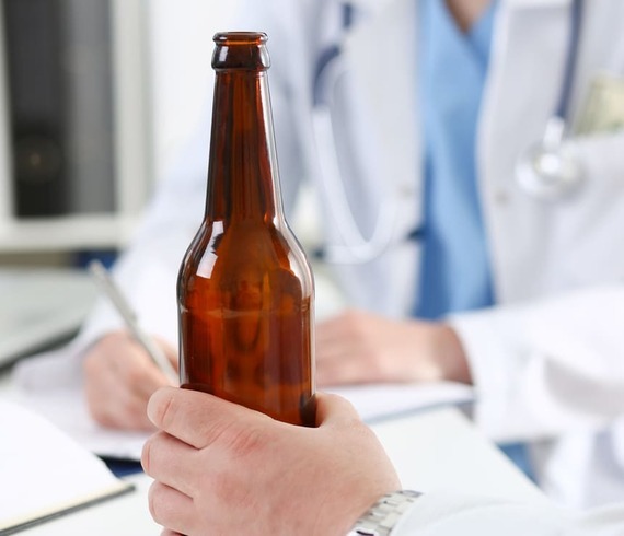 Пациент с бутылкой пива в кабинете врача